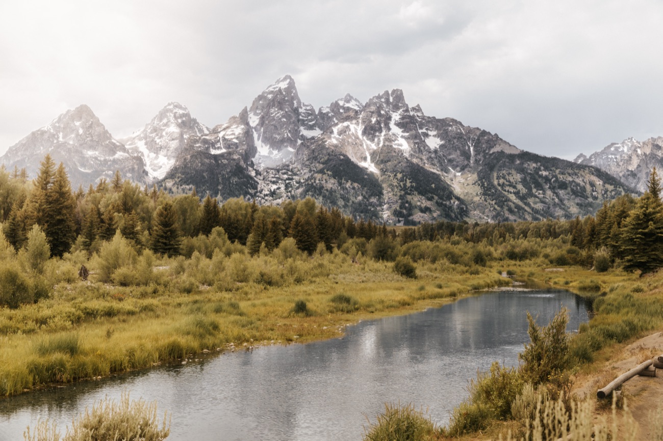 Snow-capped Grand Teton peaks above a still river, photographed by Kush Patel